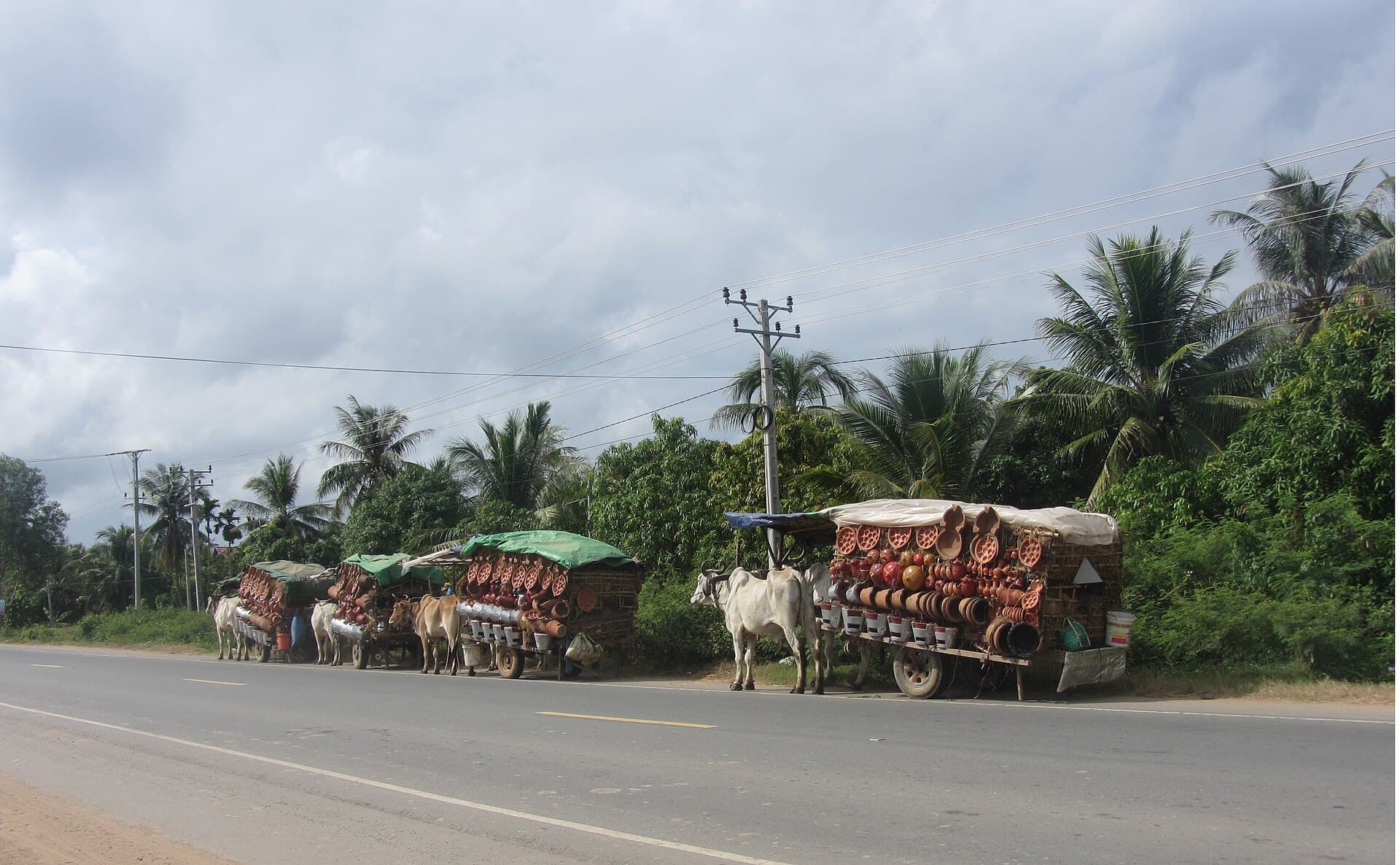 Cow carts loaded with pottery beside a road in Cambodia