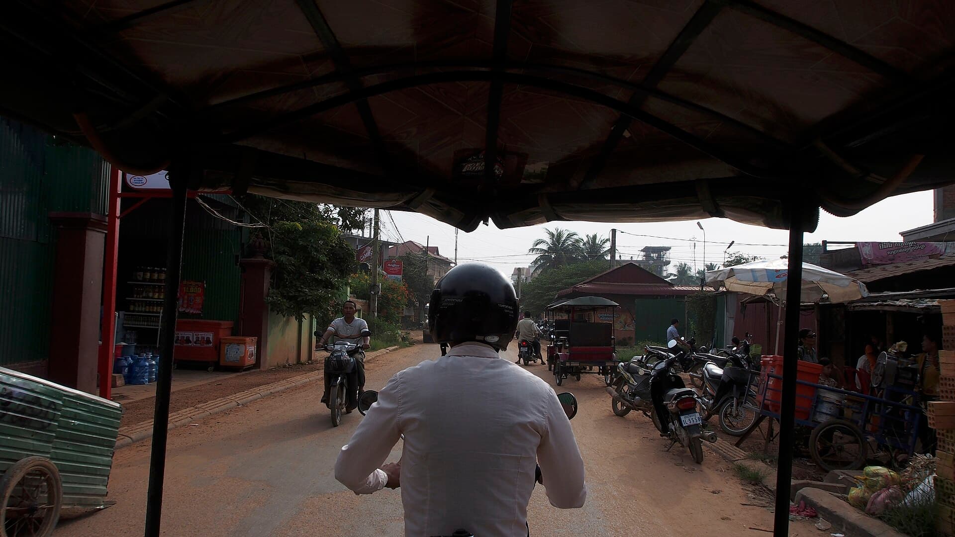View from the passenger seat of a tuk-tuk on a Cambodian road